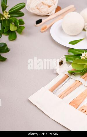 Eco craft paper tableware. A box of paper for food, cotton bag, Toothbrush, plate, forks, knives, on a gray background. world is free of plastic. Recycling concept eco-friendly . Close-Up. Stock Photo