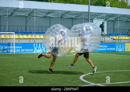Playing bubble football. People kicking football on a soccer field. August 12, 2019. Kiev, Ukraine Stock Photo