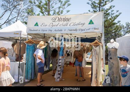 Byron Bay market and people browsing shopping at a dyed silk clothing stall in the market,New South Wales,Australia Stock Photo