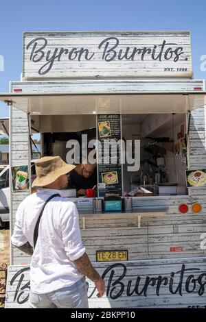 Byron Bay market man ordering burritos from a takeaway food market stall,NSW,Australia Stock Photo