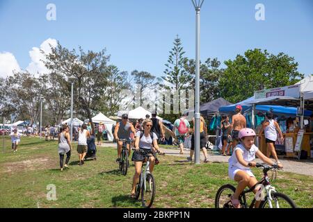 Mum Dad and daughter riding their bicycles at Byron Bay markets on a summers day,Australia Stock Photo