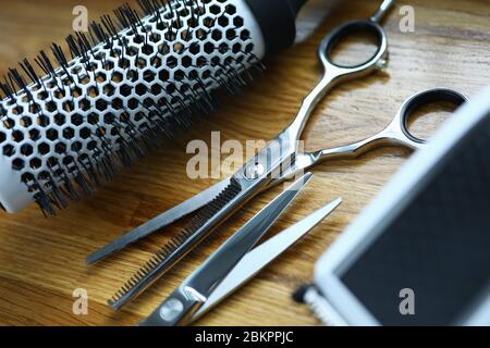 Clipper and comb lie on wooden table in hairdresser closeup Stock Photo