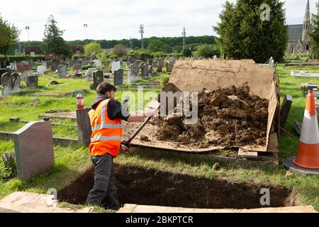 Windsor, Berkshire, UK. 5th May, 2020. A contractor digs a burial plot at a graveyard in Windsor in readiness for a funeral. There have been a number of Coronavirus Covid-19 deaths in the Royal Borough of Windsor and Maidenhead during the Pandemic. Credit: Maureen McLean/Alamy Live News Stock Photo