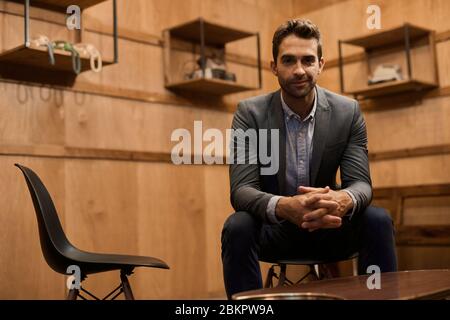 Stylish man sitting alone in a trendy lounge Stock Photo