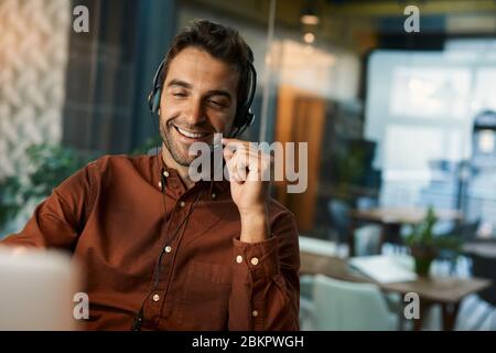 Smiling businessman talking on a headset while working late Stock Photo