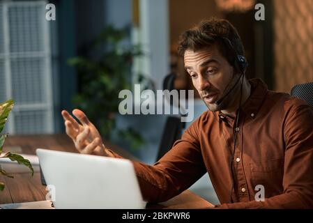 Businessman explaining something to a client over a headset Stock Photo