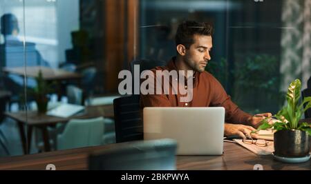Businessman working alone in an office at night Stock Photo