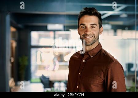 Smiling businessman working late in a dark office Stock Photo