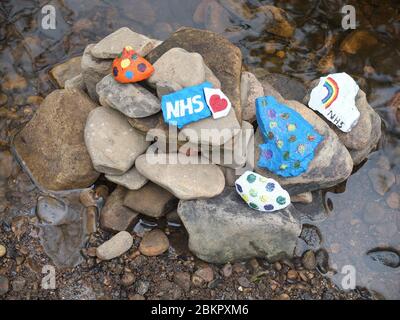 Painted stones with messages of gratitude for NHS at secret 'fairy garden' by river in Sheffield, UK, which has sprung up during Coronavirus Lockdown