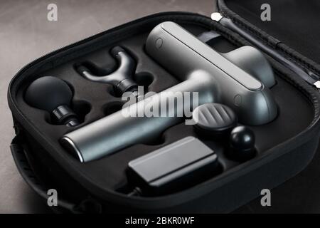 Electric massager Machine for body massage in a case on a black background.  Universal home massager for the whole body works on vibration technology  Stock Photo - Alamy