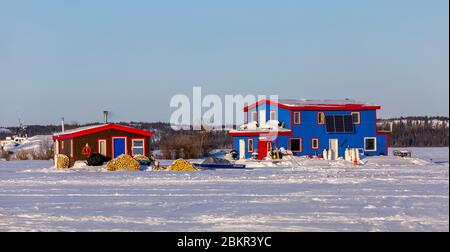 Canada, Northwest Territories, Yellowknife, houseboats resting on the frozen waters of Great Slave Lake Stock Photo