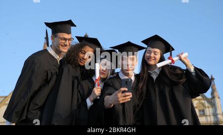 Multi ethnic group of graduated students taking selfie. Stock Photo
