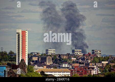 Glasgow, Scotland, UK,5th May, 2020: Seen from 9  miles away Duke Street, near Tollcross .in the east end  a huge fire billows black smoke over the city centre with the highest listed building in Scotland Anniesland court tower dwarfed although it is 7 miles away pictured from the west end. . Gerard Ferry/ Alamy Live News Stock Photo