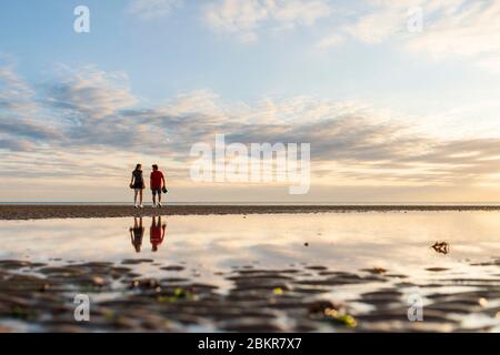 France, Manche, Saint-Laurent-sur-Mer, Sunrise at Omaha beach and cycle tourists along the V?lo Maritime route Stock Photo