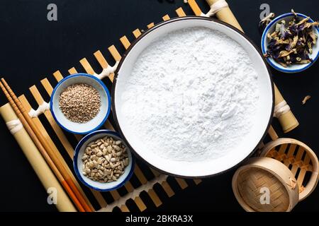 Healthy food concept ingredients for Vegan Gluten free Homemade Asian fried glutinous rice flat pancake with sesame and sunflower seeds on black baclg Stock Photo