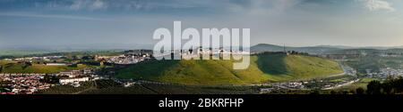 Wide panorama of the Garrison Border Town of Elvas as seen from Grace fort hill under a clouded blue sky. The new part of town to the left and the Amo Stock Photo