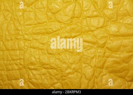 Parcel envelope. Crumpled yellow paper texture. Top view, horizontal layout. Yellow postal cardboard package with bubble wrap inside. Copy space on Stock Photo