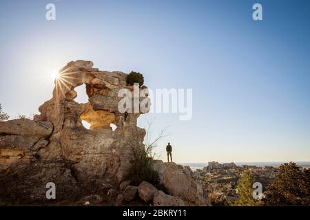 France, Bouches-du-Rh?ne, Alpilles regional natural park, Les Baux de Provence, labeled Les Plus Beaux Villages de France, Val d'Enfer, cliff pierced by caves, the village and the castle in ruins behind -plan Stock Photo