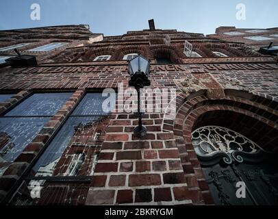 Lueneburg, Germany, April 8., 2020: Brick building in the old town of Lueneburg, from down, with a lantern in wrought-iron frame Stock Photo