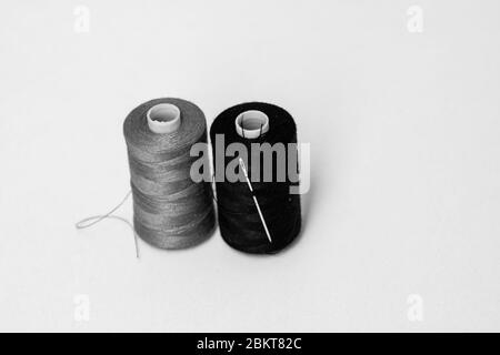 Black thread spool with needle Stock Photo - Alamy