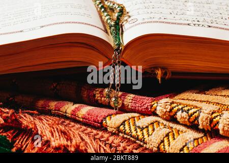 Holly Quran and praying beads on prayer mat close up in Ramadan Kareem Stock Photo