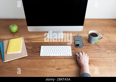 Front view of home office or home work space with computer, apple, pencil, notepad on wooden desk Stock Photo
