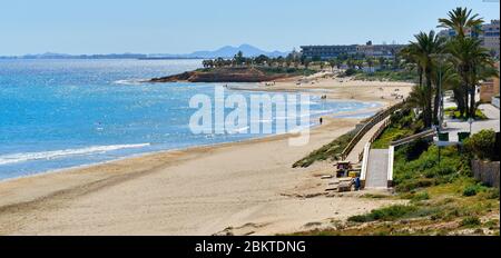Panoramic image picturesque scenery idyllic landscape view, people enjoy warm weather walking on Mil Palmeras Spanish Costa Blanca beach Stock Photo