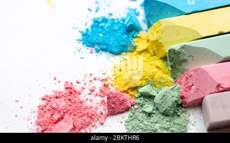 Crumbs of multi-colored chalk on a white background. Joy, Carnival. A game for children. Art Stock Photo