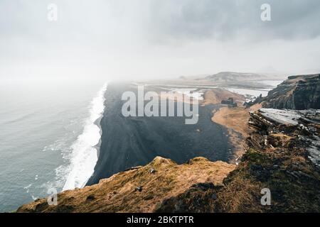Moody Black Sand Beach in Iceland during the rainy and foggy weather reflects the typical weather conditions of north countries Stock Photo