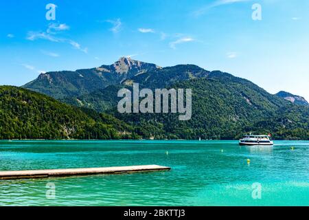 Beautiful view on Wolfgangsee lake by in St Sankt Gilgen with alps mountains, boats, Sailboats, blue sky, clouds, Schafberg mountain, ship.  Salzkamme Stock Photo