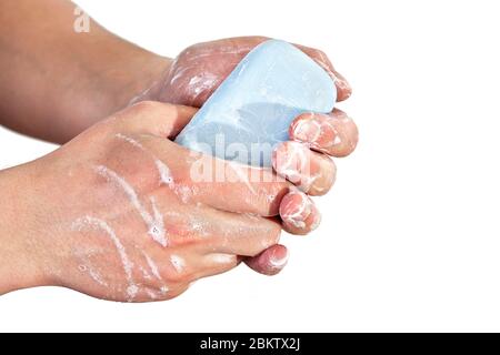 Young man washing hands with blue soap bar, isolated on white. Can be used during coronavirus covid 19 outbreak prevention Stock Photo