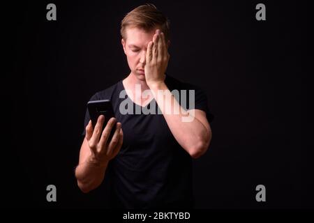 Portrait of stressed young man using phone Stock Photo