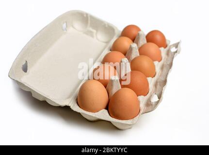 Ten brown eggs in a carton package. Top view. Ten brown eggs in a cardboard box. Eggs. Stock Photo