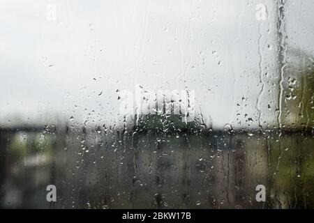 Raindrops on the window pane. Blurred background outside the window in the rain. Stock Photo