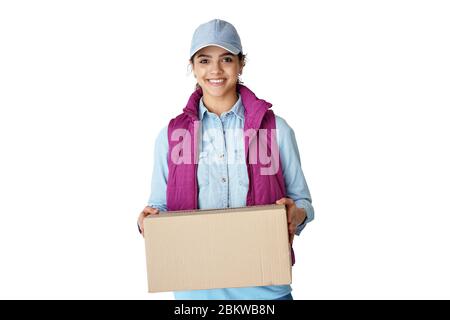 Smiling young hispanic woman courier holding delivery box isolated on white. Stock Photo