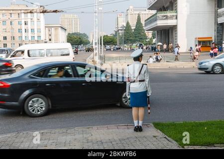 Pyongyang, North Korea - July 29, 2014: A girl policeman regulates traffic at a crossroads in Pyongyang. One of the symbols of Pyongyang. Stock Photo