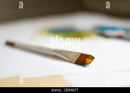Photo of a brush in acrylic multi-colored paint close-up Stock Photo