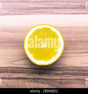 Symmetrical yellow half of lemon turned upward on a table with horizontal texture Stock Photo