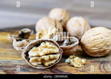 Big ripe walnuts on the wooden background closeup. Healthy frui walnut macro. Stock Photo