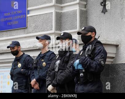 Kiev, Kyiv, Ukraine. 5th May, 2020. Police officers stand guard outside the Ministry of Health while wearing a face mask as a preventive measure against the spread of COVID-19 during the pandemic.Ukrainian government has extended the coronavirus quarantine in the country until 22 May 2020. As on May 05, 2020 Ukraine's Health Ministry recorded in total 12,697 confirmed cases and 316 deaths since the beginning of the outbreak. The disease was confirmed in 881 children and 2,479 medics. Credit: Pavlo Gonchar/SOPA Images/ZUMA Wire/Alamy Live News Stock Photo