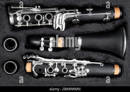 black clarinet  silver wooden woodwind musical brass instrument in pieces parts in music case. classic orchestra symphony background. Stock Photo