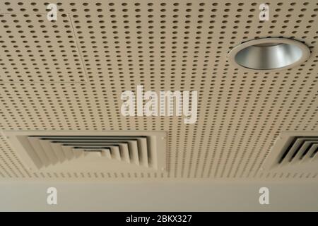 White sound absorption ceiling with duct grilles and lights Stock Photo