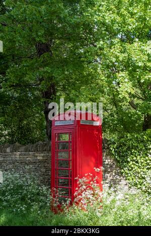 Old fashioned retro red phone box in Swinbrook, the Cotswolds, Oxfordshire, UK Stock Photo