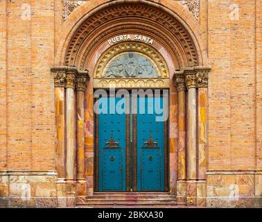 Entrance with turquoise door of the New Cathedral in Cuenca, Ecuador. Translation on the door: 'Puerta Santa' = 'Holy Door'. Stock Photo