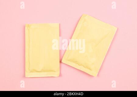 Two white paper sachets isolated on pink background. Top views with clear space Stock Photo