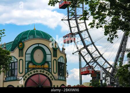 Ferris wheel and welcome building with the Austrian greeting 'Habe die Ehre' at Prater, the public amusement park of Vienna, capital of Austria. Stock Photo