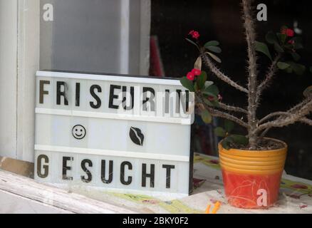 Brandenburg A.D.Havel, Germany. 30th Apr, 2020. A sign with the inscription 'Friseurin gesucht' ('Hairdresser wanted') stands next to a cactus in the shop window of a hairdresser's shop. Credit: Soeren Stache/dpa-Zentralbild/ZB/dpa/Alamy Live News Stock Photo