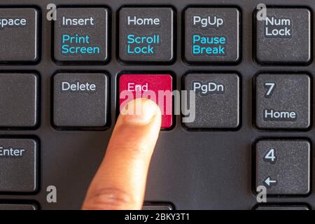 End key highlight with Red color, with finger pressing button on keyboard isolated on white background Stock Photo