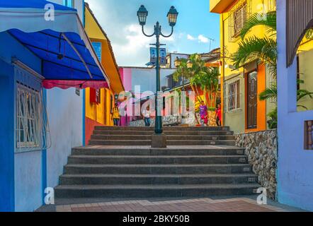 Young Ecuadorian people walking down the steps in the colorful Las Penas district on Santa Ana Hill with colonial architecture, Guayaquil, Ecuador. Stock Photo