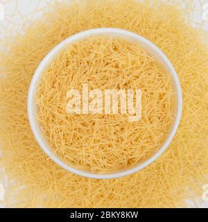 Raw vermicelli pasta in a bowl isolated on white background. Stock Photo